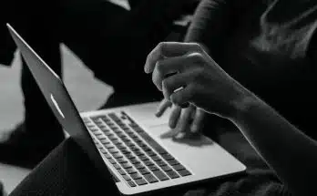 grayscale photo of person using MacBook